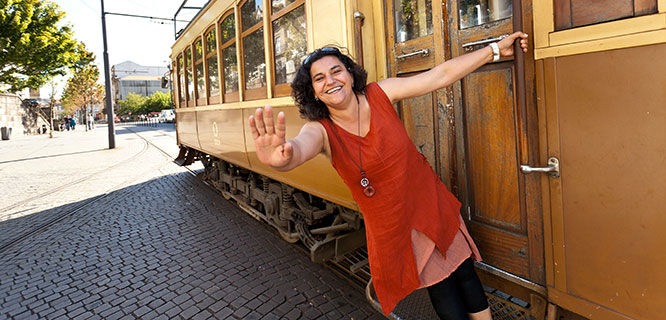lady in red dress next to yellow trolley