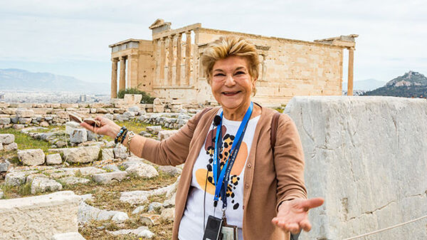 Tour member standing by stone at Acropolis, Athens, Greece