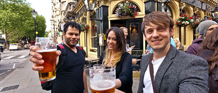 Trio toasting in pub, London, England