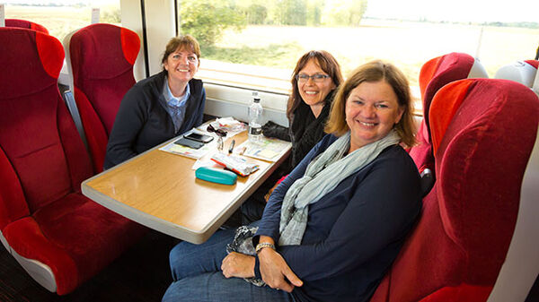Three women sitting at table in train