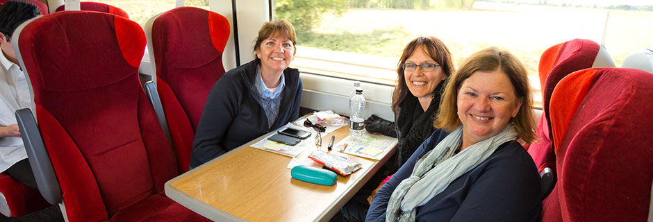 Three women sitting at table in train