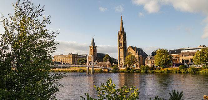 cathedral at the end of a pedestrian bridge over the river ness