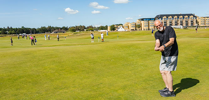 man on golf course taking a swing