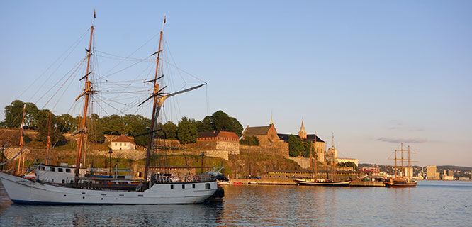 old fortress and sailing ship in oslo harbor