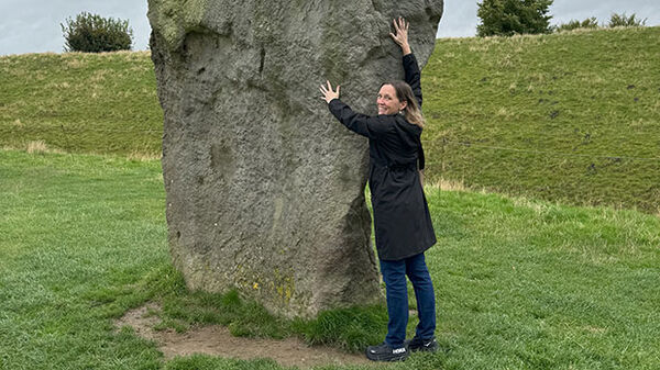 woman standing next to ancient stone