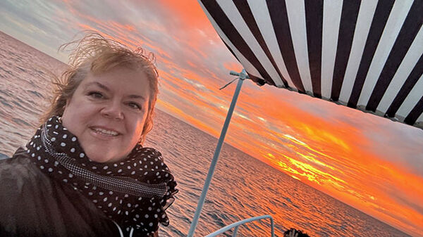 woman on boat with pink sky