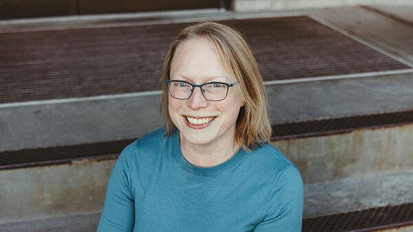 woman is teal shirt sitting on stairs