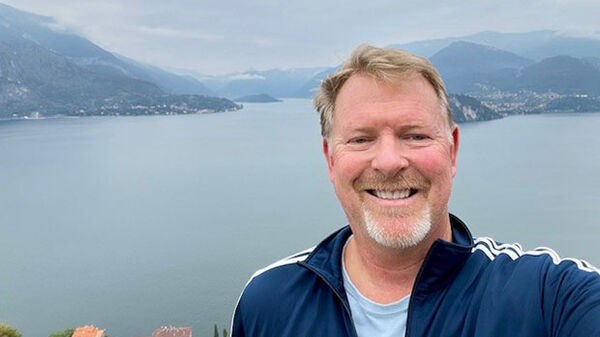 man with water and mountains in background