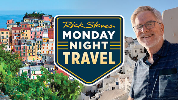 colorful buildings on a cliff on left Rick Steves on right