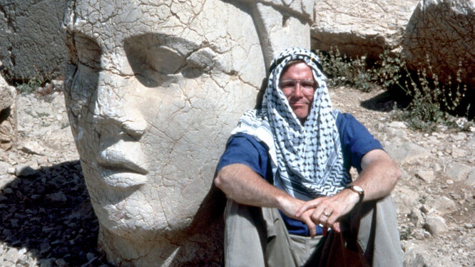 Rick Steves and a stone head at Mount Nemrut, Turkey