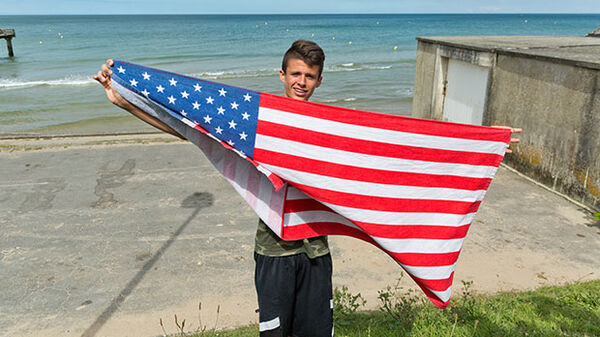 Boy with American flag on Omaha Beach, Normandy, France