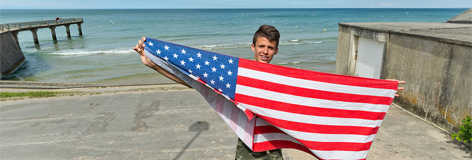 Boy with American flag on Omaha Beach, Normandy, France