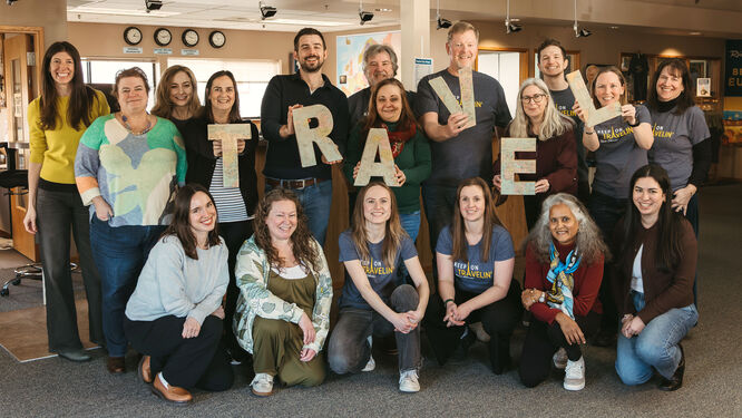 group of people holding letters that spell travel