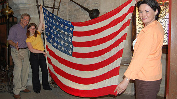 Rick with two girls holding WWII US flag, Beaune, France