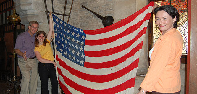 Rick with two girls holding WWII US flag, Beaune, France