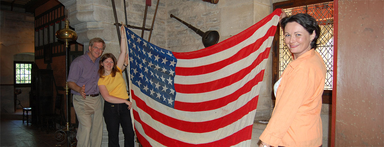 Rick with two girls holding WWII US flag, Beaune, France