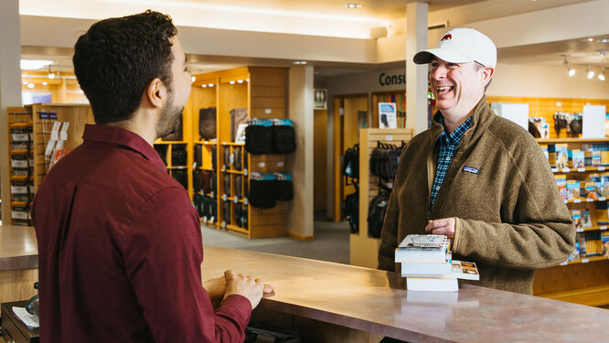 two men talking at a counter