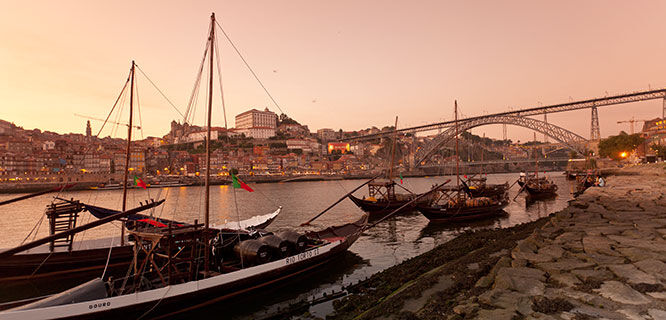 boats on a river with a peach color sky