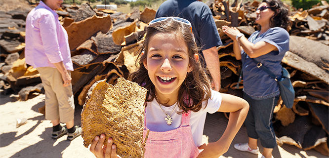 young girl holding a large piece of cork