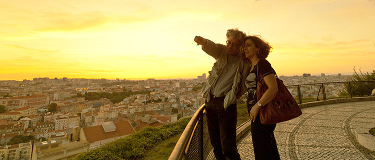 Couple looking over city at sunset, Lisbon, Portugal