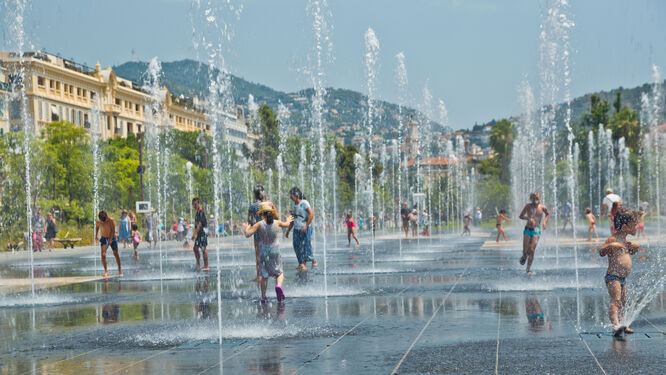 people in a fountain with streams of water shooting up from the ground