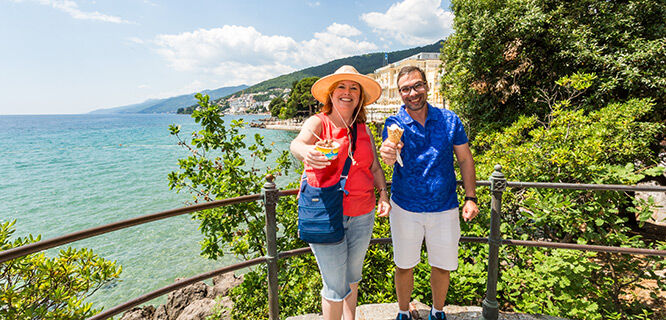 woman and man eating ice cream overlooking sea view