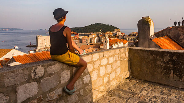 Person sitting on town wall, Dubrovnik, Croatia