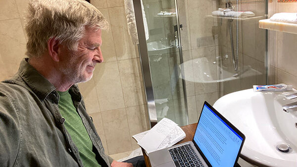 Rick Steves working in a hotel bathroom
