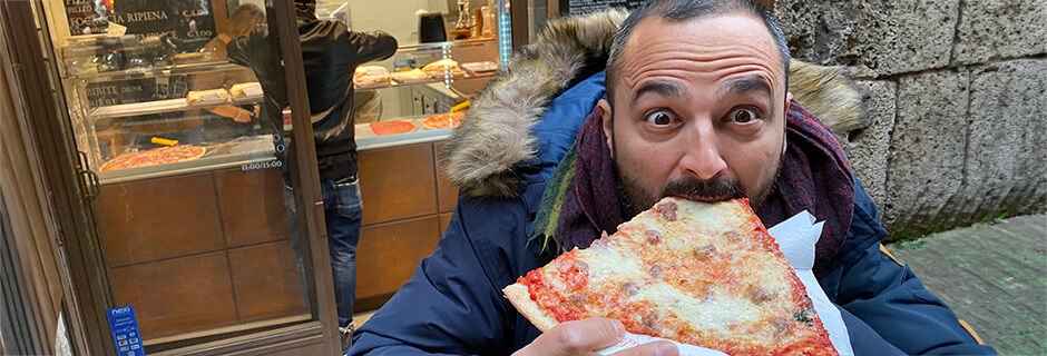 Man eating a slice of pizza, Florence, Italy
