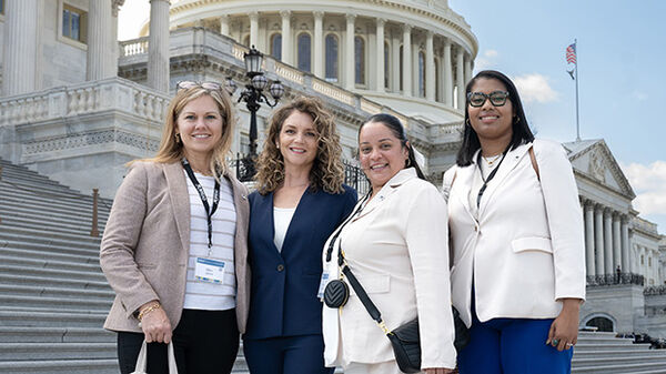 four women standing in front of us capitol