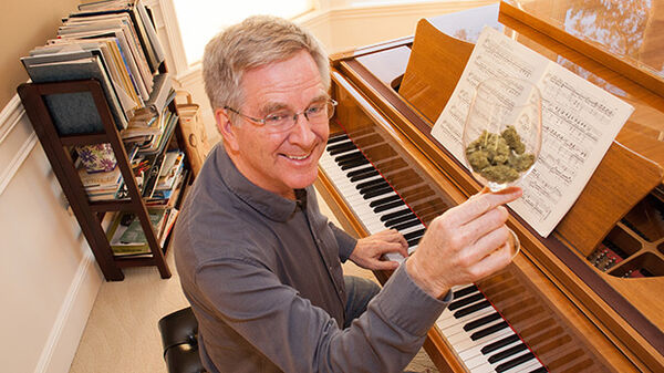 rick holding a goblet at the piano