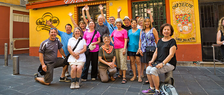 Tour group waving outside restaurant, Nice, France