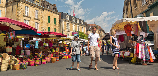 three people walking in an outdoor market